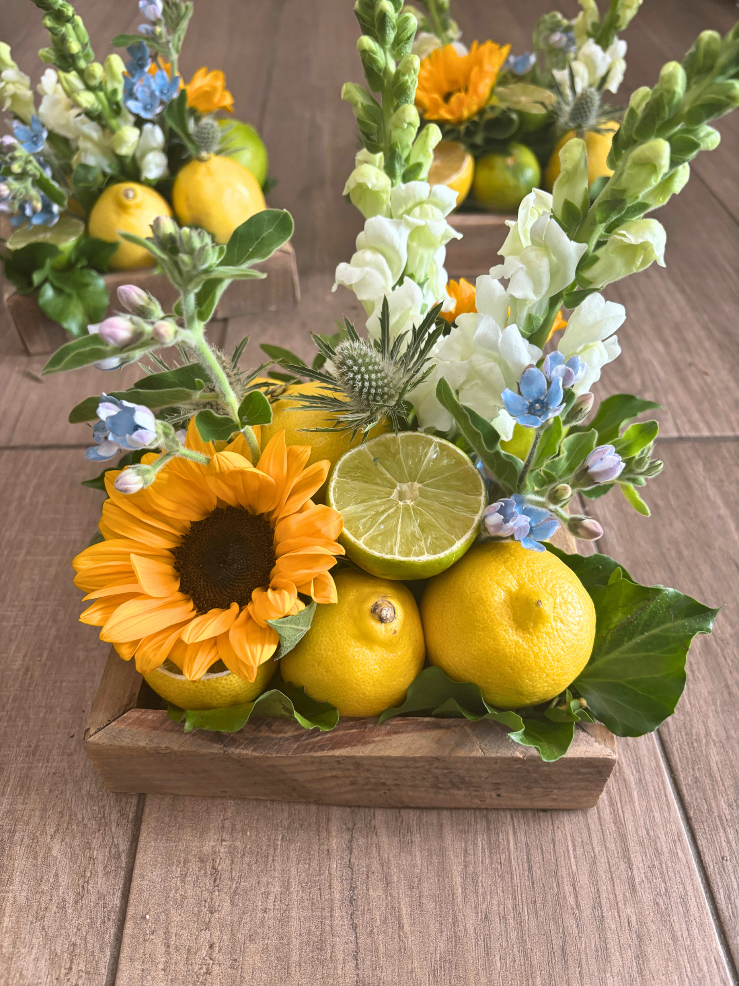 Composition estivale avec tournesol, citrons et fleurs fraîches